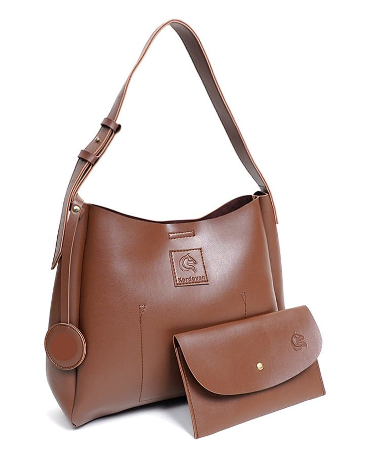 Brown leather handbag with matching wallet on a white background