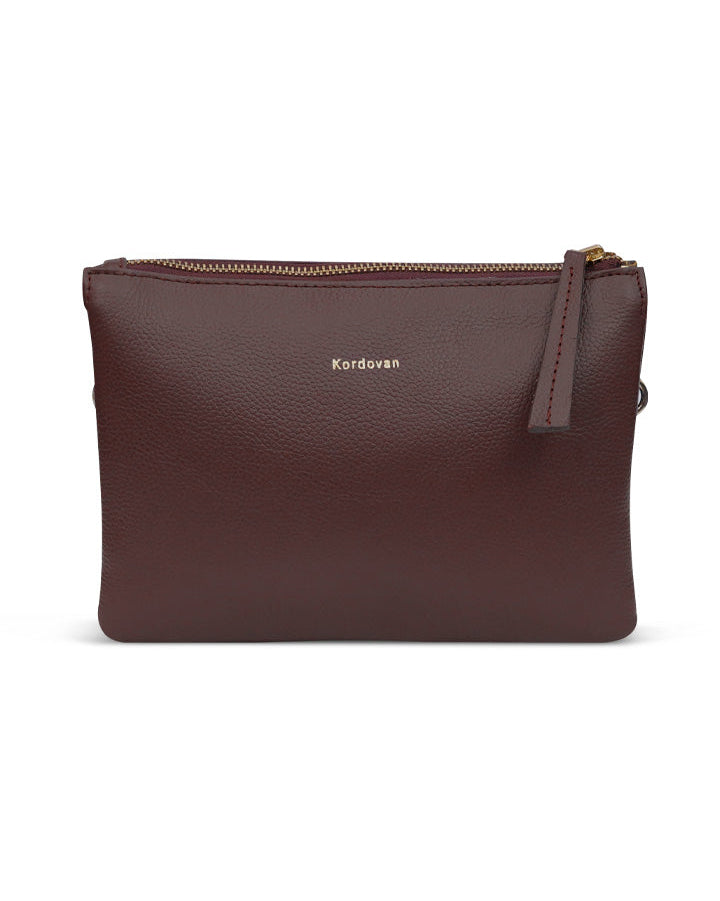 A brown pebbled leather cross-body bag with a zipper closure and a detachable strap.