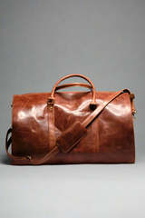 A brown premium top-grain leather duffle bag with dedicated compartments for suits, shoes, ties, and essentials, displayed in a flat position with the capacity to stand upright.