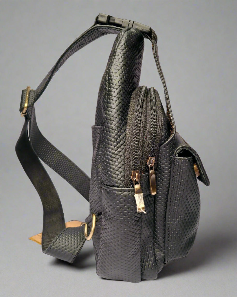 Black textured bag with gold zippers on a light gray background