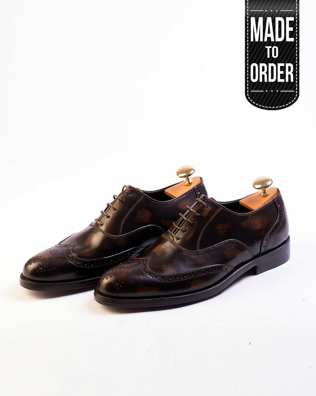 A pair of brown Salemanco Brogue shoes with a burnished finish, featuring intricate perforations and a lace-up closure.