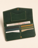 The Cleopatra wallet open — card slots and cash compartment with brass snap closure