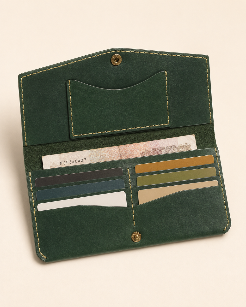 The Cleopatra wallet open — card slots and cash compartment with brass snap closure