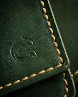 Close-up of the emerald full-grain leather grain and hand-stitching on the Cleopatra wallet