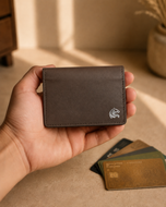 Brown leather Elite Card Holder held in hand for scale