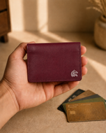 Burgundy leather Elite Card Holder held in hand, slim profile visible