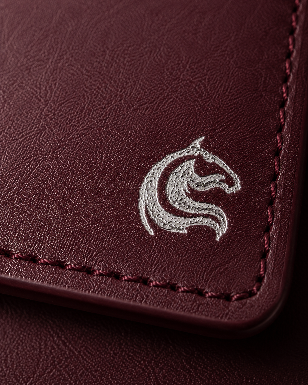 Close-up of the burnished burgundy leather grain on the Elite Card Holder