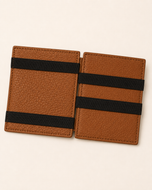 ILLUSION magic wallet open — crossed elastic straps holding banknotes in place