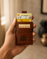 Brown Kodo Vertical 2.0 slim RFID wallet held in hand, pull strap visible