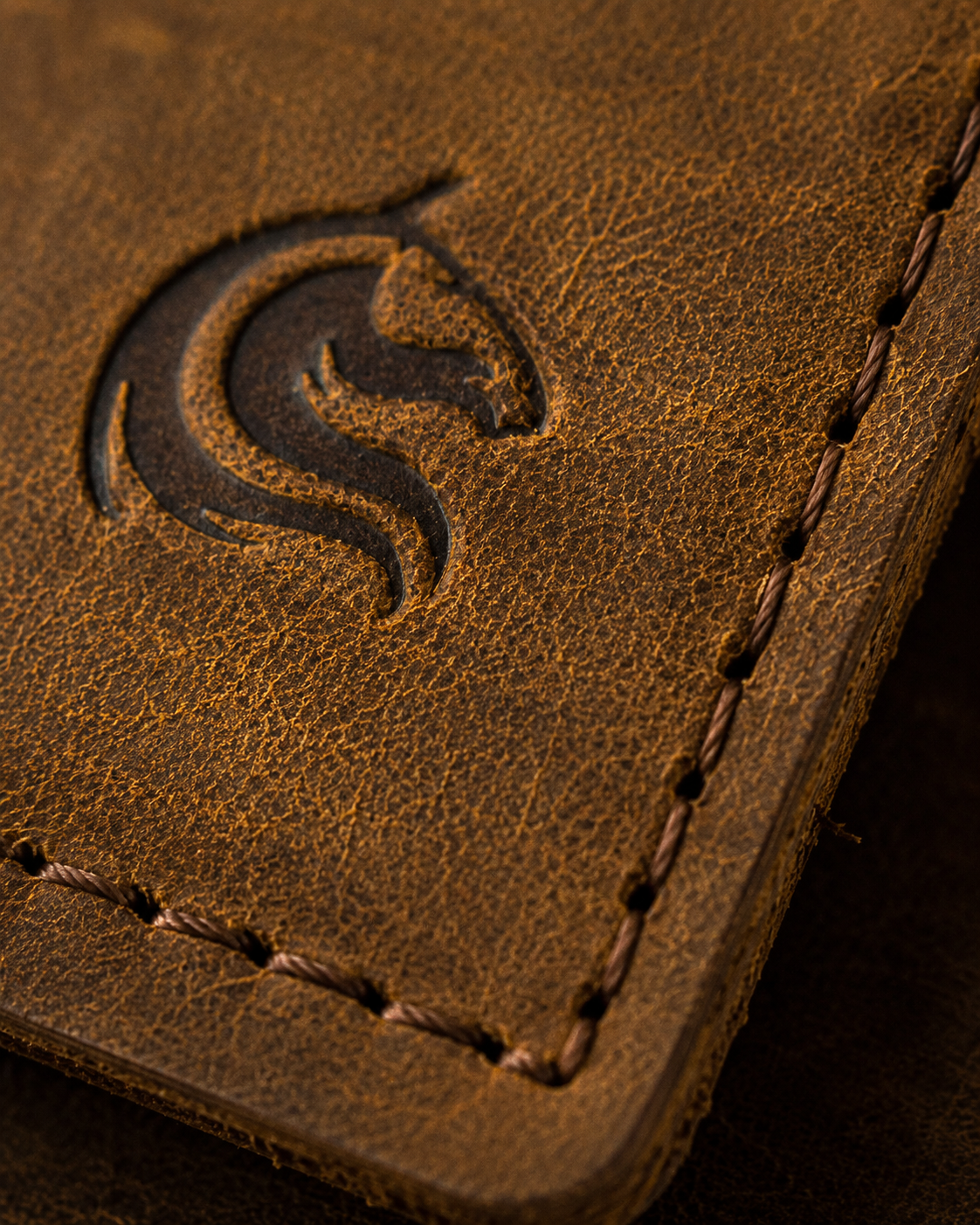 Close-up of the full-grain cow leather grain and hand-stitching on The Luke wallet