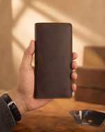 Light brown Crazy Horse leather long wallet held in hand, showing full-length size