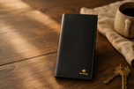 The Elite Midnight Black mobile wallet styled on a desk — Kordovan leather everyday carry