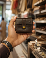 Mocha Mate brown leather bifold wallet held in hand