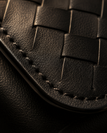 Close-up of the handwoven black leather texture on the Nova clutch