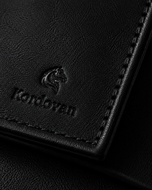 Close-up of the black nappa leather and seaming details on the Kordovan bifold