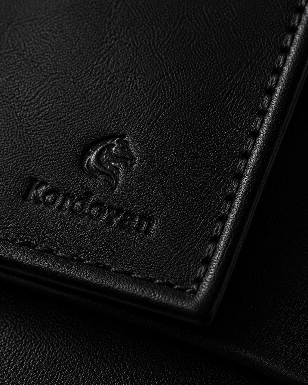 Close-up of the black nappa leather and seaming details on the Kordovan bifold
