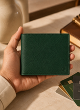 Emerald green saffiano leather bifold wallet held in hand, cross-hatch grain visible