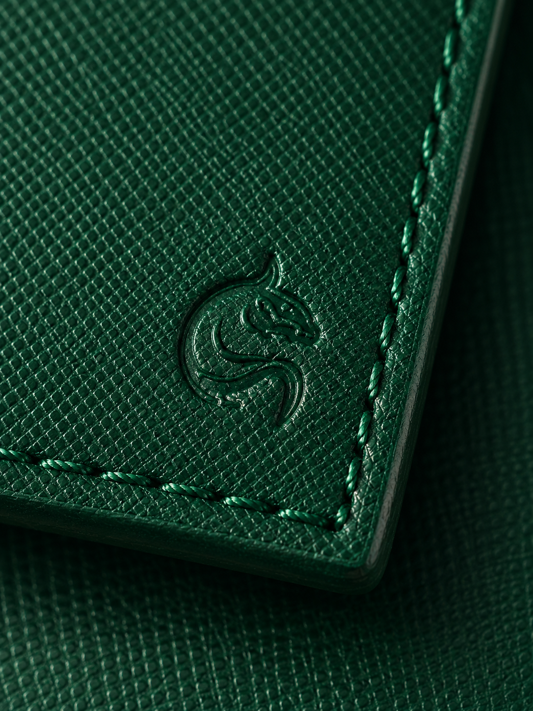 Close-up of the matte cross-hatched saffiano leather on the emerald green Kordovan wallet
