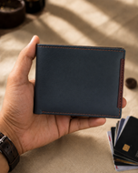 Thomas milled leather bifold wallet held in hand for scale