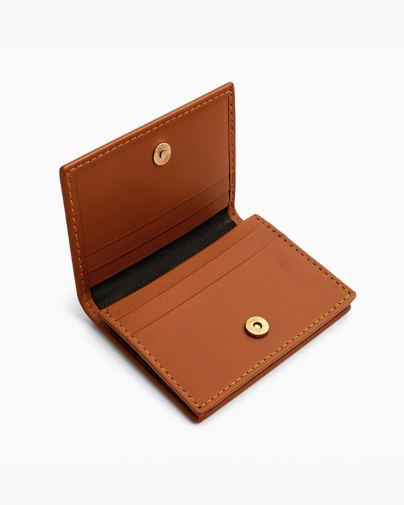 Tan leather wallet with gold buttons on a white background