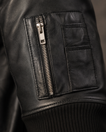 The Ace — men's black MA-1 leather bomber jacket, close-up of the leather grain and hardware | Kordovan Pakistan