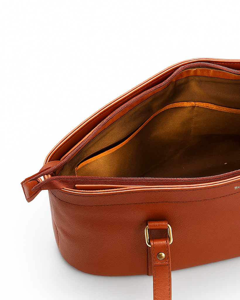 Tan leather handbag with gold accents on a white background