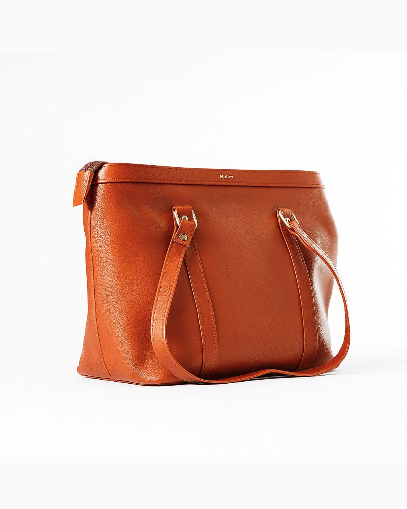 Tan leather handbag on a white background