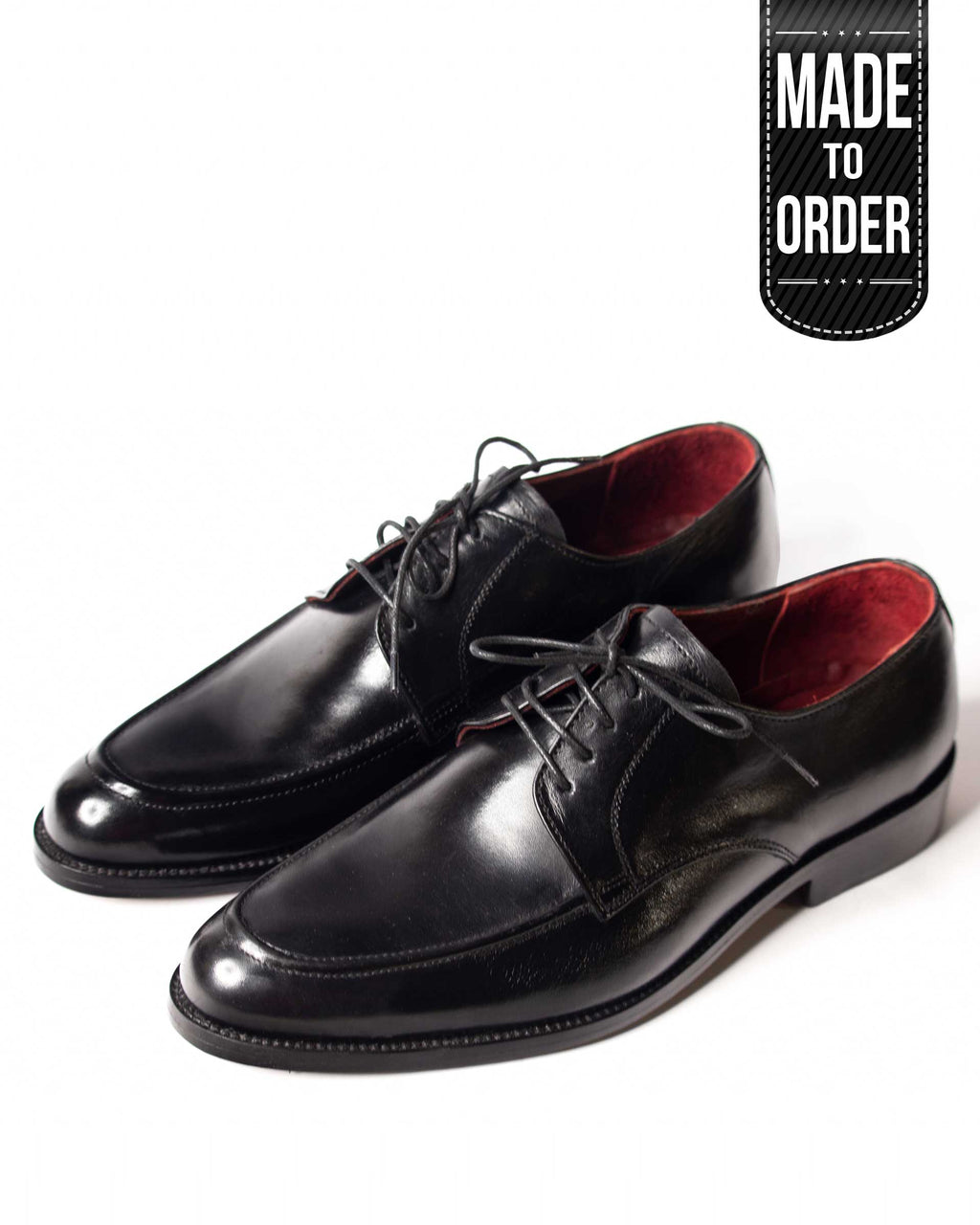 A pair of black leather oxford shoes with a lace-up closure. The shoes have a polished, glossy finish and visible stitching details.